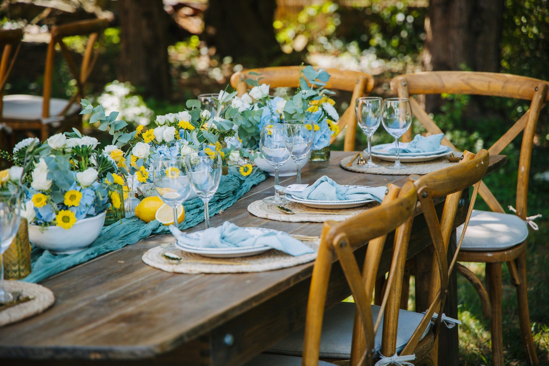 Outdoor table setting with floral arrangements and lemons.
