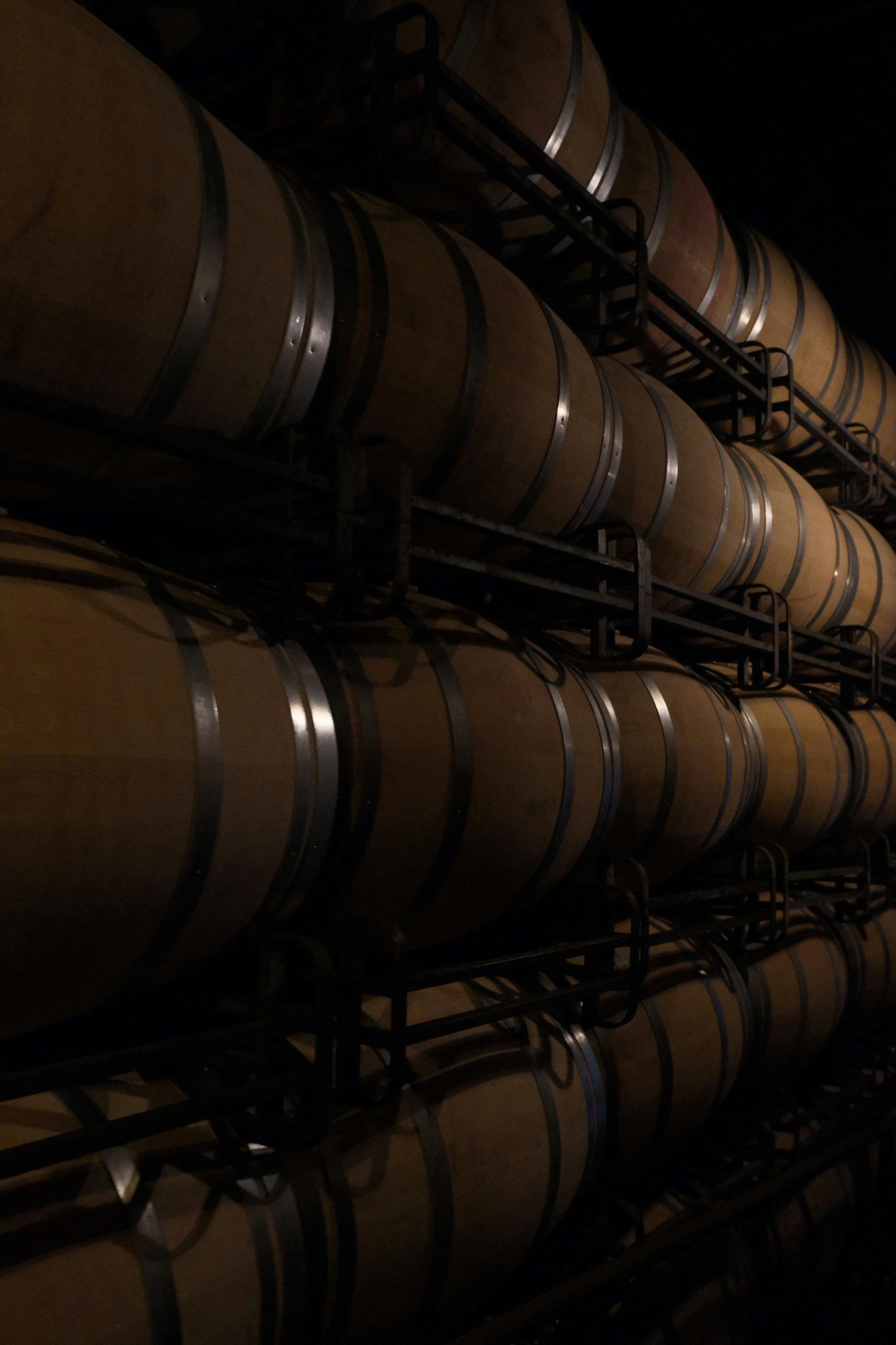 Stacked wine barrels in a dark cellar